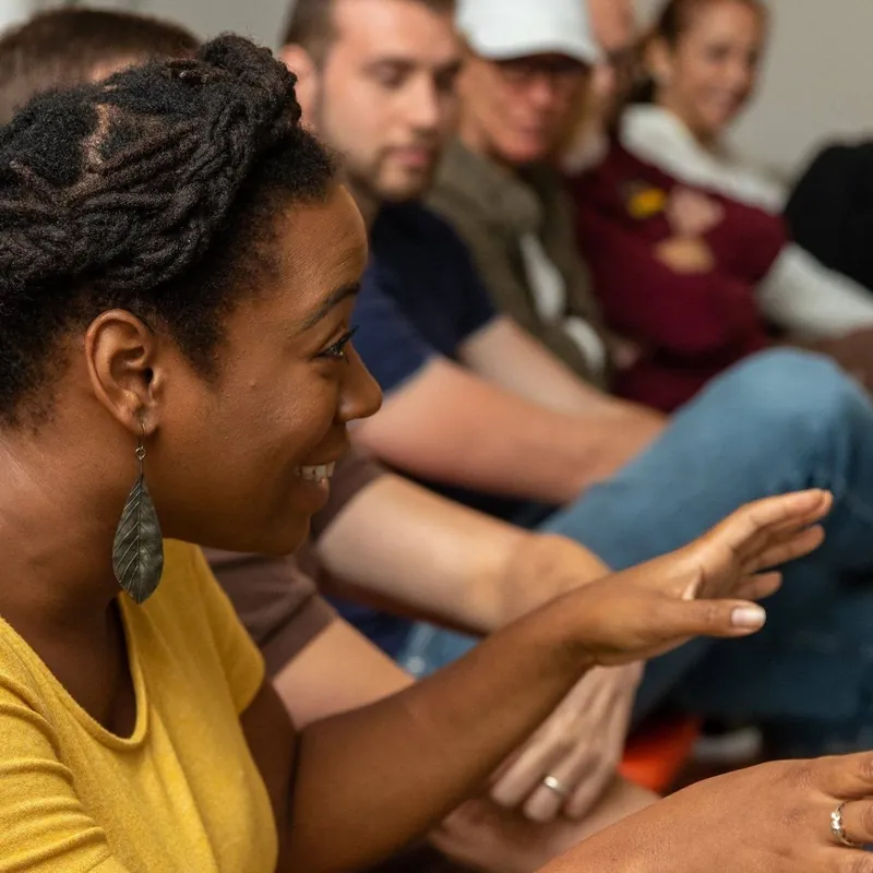 Asha Bland smiling and talking with a group