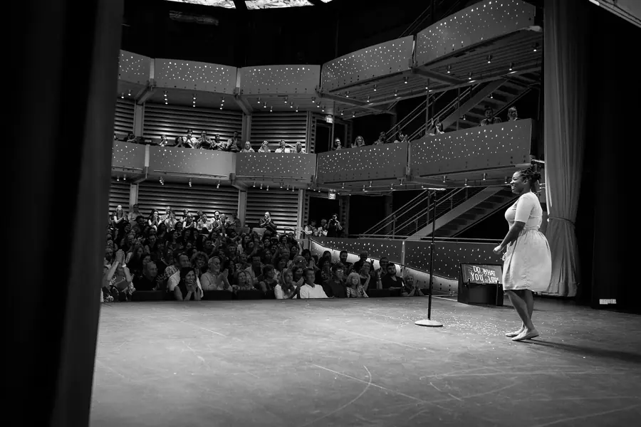 Black and white photo of Asha on a large theater stage